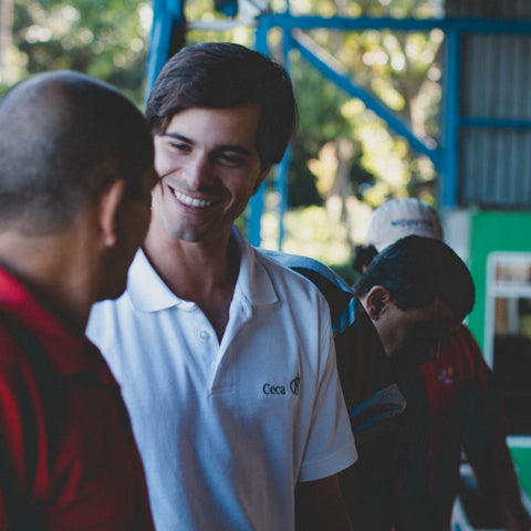 Two men talking outdoors with a blurred background